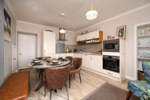 a kitchen with a table and chairs in a room at Shore View Cottage in Inverness