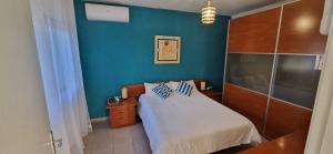 a bedroom with a bed and a blue wall at Le Petit Paradis Olivella in Olivella +71 photos