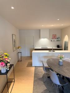 a kitchen and living room with a table and chairs at Sien Suite in Brakel