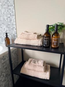 a shelf with two towels and two bottles of soap at Sien Suite in Brakel