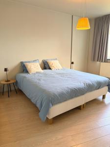 a bedroom with a large bed with a blue comforter at Sien Suite in Brakel