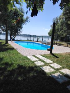 a swimming pool next to a beach with the ocean at Vikend kuća na Dunavu - Vila Čoče in Kovin