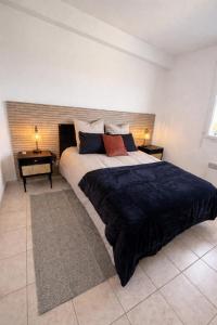 a bedroom with a large bed with two tables and two lamps at La Pause Larzac- T3 calme-terrasse - Proche Viaduc de Millau in La Cavalerie