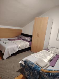 a bedroom with two beds and a wooden cabinet at Vikend kuća na Dunavu - Vila Čoče in Kovin
