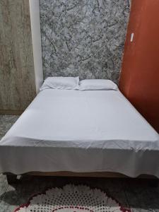 a bed with two pillows on it in a room at Apartamento confortável em Cuiabá in Cuiabá