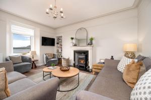 a living room with a couch and a fireplace at Shore View Cottage in Inverness