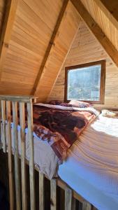 a bed in a log cabin with a window at Mountain View in Tjentište