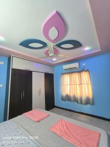 a bedroom with a ceiling fan and a bed at Dev Homestay kakinada in Kākināda