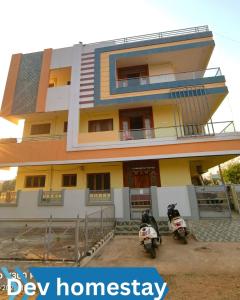 a building with two motorcycles parked in front of it at Dev Homestay kakinada in Kākināda