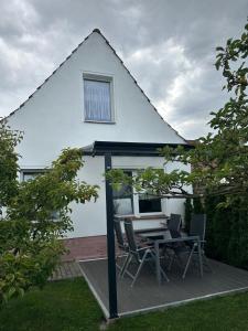 a patio with a table and chairs in front of a house at Ferienwohnung Schulrath in Eichwerder