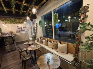 a restaurant with a bench with tables and a window at Oxbackens Hotell & Café in Västerås