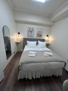 a bedroom with a large bed with two towels on it at Oxbackens Hotell & Café in Västerås