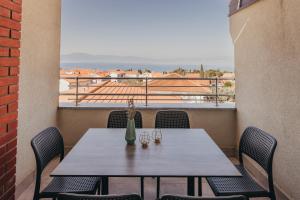 a table on a balcony with a view of the ocean at Lavanda Rooms & Apartment - Malinska in Malinska