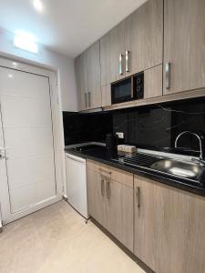 a kitchen with a sink and a microwave at Agathi Paradise Studios in Haraki