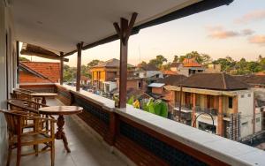 a balcony with chairs and a view of a city at Rumah Rini by Rumah Weda in Ubud