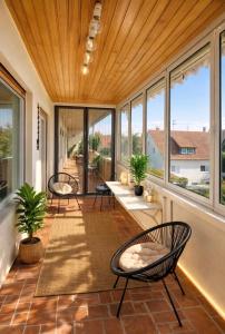 a screened in porch with two chairs and windows at Sternlicht Rachida in Albstadt