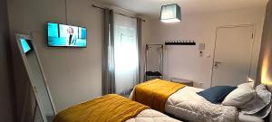 a room with two beds and a tv on the wall at Casa 2 Andrades in Belmonte