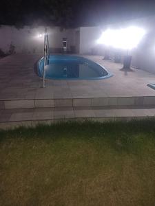 a large swimming pool at night with a light at Casa próxima a orla in Pelotas