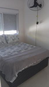 a bedroom with a bed with a fan and a window at Casa próxima a orla in Pelotas