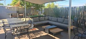 a patio with a couch and a table and chairs at Vondelhof Guesthouse in Windhoek