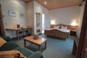 a hotel room with a bed and a couch and a table at Vergissmeinnicht in Oberhof