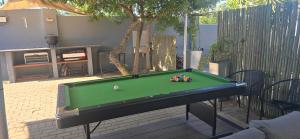 a green pool table with a ball on top of it at Vondelhof Guesthouse in Windhoek
