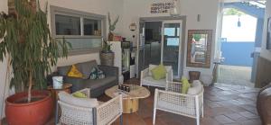 a living room with a couch and tables and chairs at Vondelhof Guesthouse in Windhoek