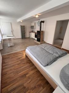 a bedroom with a large bed and a kitchen at Main Tauber Appartment in Lauda-Königshofen