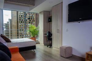 a bedroom with a bed and a flat screen tv at Confortable Apartamento Centro de Bogotá in Bogotá