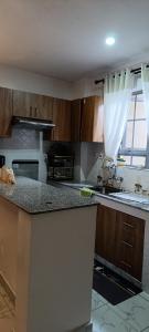 a kitchen with wooden cabinets and a counter top at Zangem Homes in Nairobi