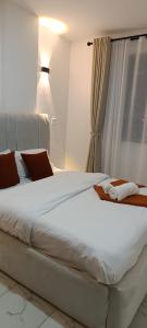 a large white bed in a room with a window at Zangem Homes in Nairobi