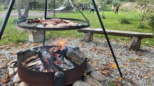 a barbecue grill with meat and a fire at Wypas Hills - domek na wyłączność in Białka Tatrzańska