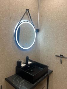 a bathroom with a black sink and a mirror at Oxbackens Hotell & Café in Västerås