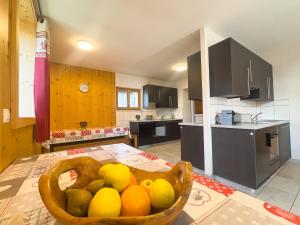 a kitchen with a bowl of fruit on a table at Gîte de chandonne in Liddes +24 photos