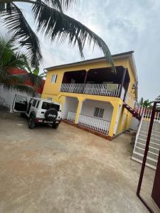a yellow house with a truck parked in front of it at Holiday Home T3 to T6 on suite in Amparo II