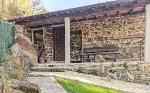 a stone house with a wooden door and stairs at A Nosa Casa 2 in Belesar