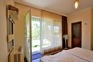 ein Schlafzimmer mit einem Bett und einem großen Fenster in der Unterkunft Hotel Vardzia K A L A in Aspindza