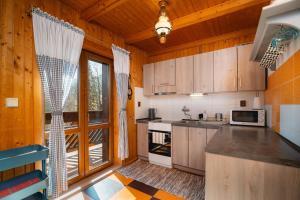 a kitchen with wooden cabinets and a large window at Chata Zuzana in Terchová