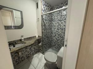 a bathroom with a toilet and a sink and a mirror at Flat Jardim de Allah in Campos dos Goytacazes +13 photos
