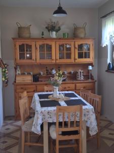 a dining room with a table with chairs and a kitchen at Bieszczadzki Dworek in Ustrzyki Dolne