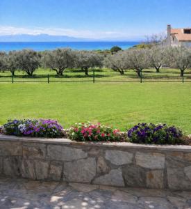 a retaining wall with flowers in a park at Private Villa Sea View BBQ in Epanomi