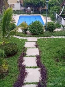 a stepping stone path leading to a swimming pool at Newly renovated apartment with pool in Santa Cruz Huatulco