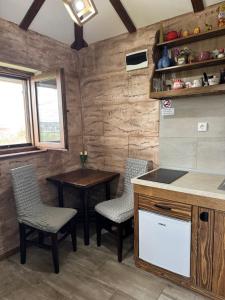 a kitchen with two chairs and a table and a counter at Apartmani Mladenovac in Mladenovac