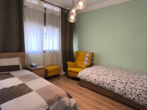 a bedroom with a bed and a yellow chair at Imperial Rabat - MAKE IT YOURS in Rabat