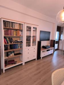 a living room with a tv and book shelves at Imperial Rabat - MAKE IT YOURS in Rabat