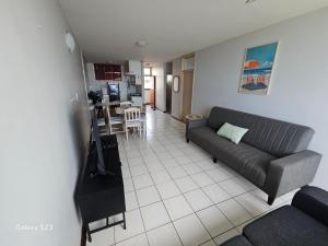 a living room with a couch and a kitchen at Ocean Whisper 405 in Scottburgh