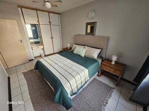 a bedroom with a large bed and a window at Ocean Whisper 405 in Scottburgh +18 photos