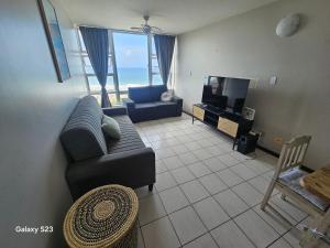 a living room with a couch and a television at Ocean Whisper 405 in Scottburgh