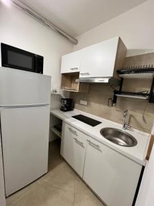 a small kitchen with a sink and a refrigerator at Casa Anna in Costa Rei
