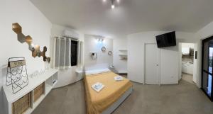 a large white room with a bed and a tv at Casa Anna in Costa Rei